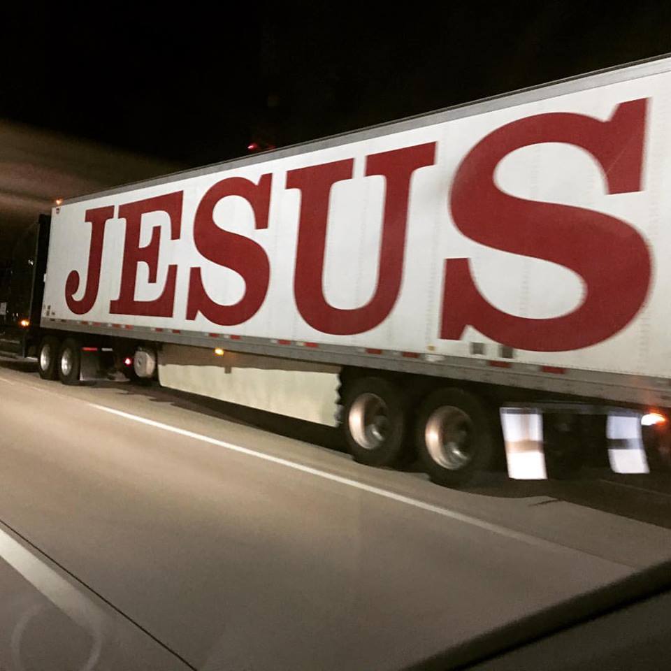 A semi truck with the word JESUS painted on the side
