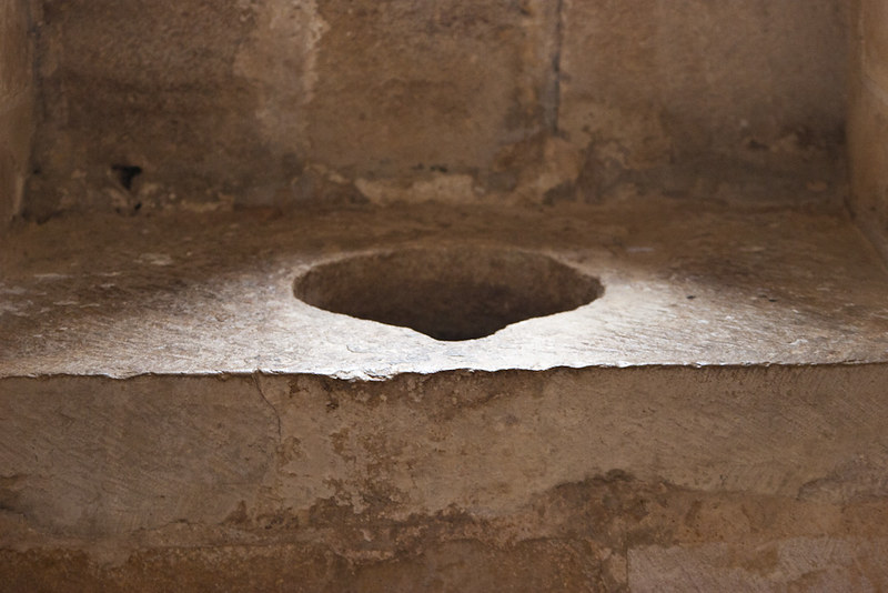 Flat stone with a circular hole cut in the center, like a privy. (Photo by Isabel via Flickr/Creative Commons https://flic.kr/p/denN7G)