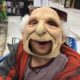 Three year old tries on a grumpy old man mask