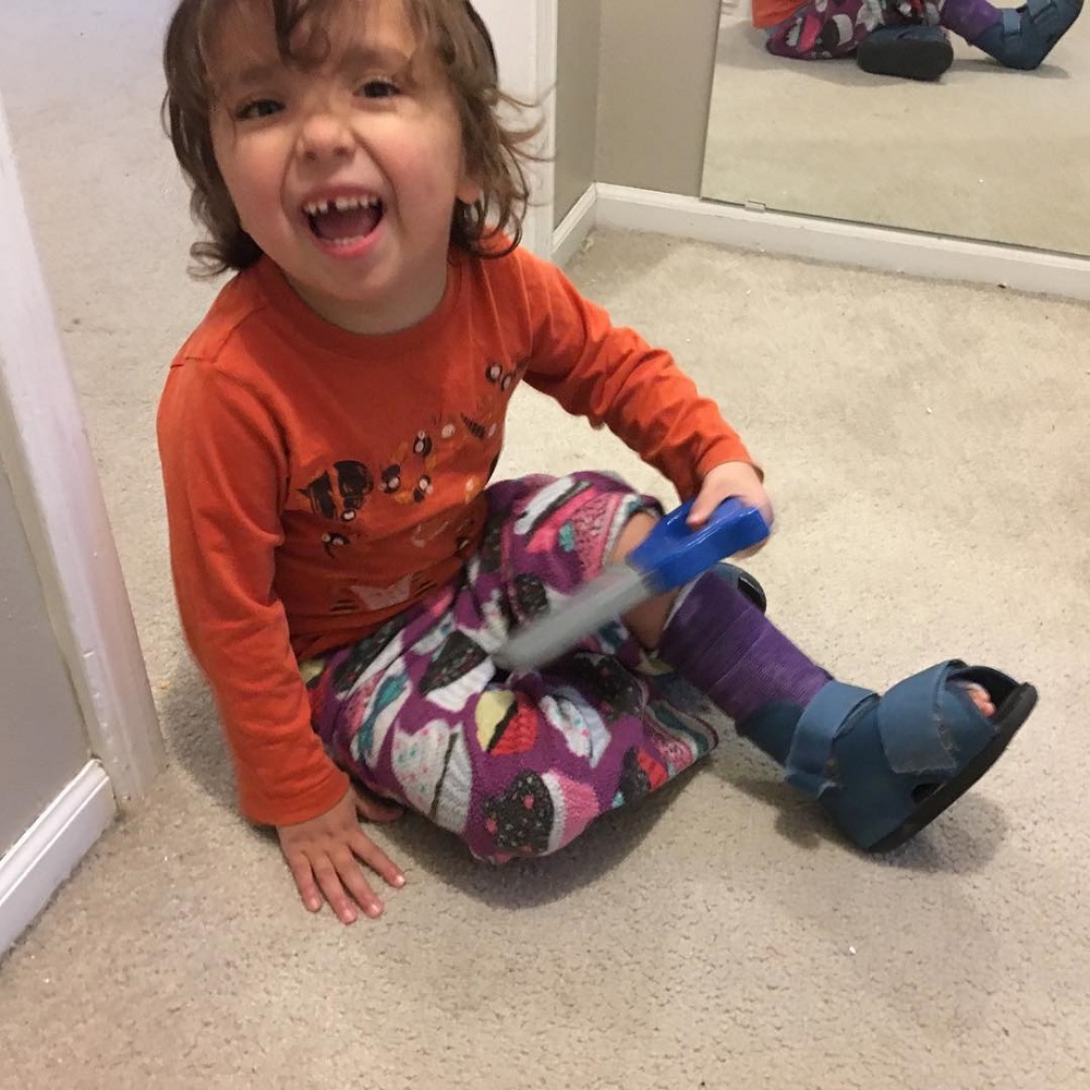 Three year old laughs as he pretends to saw his leg off
