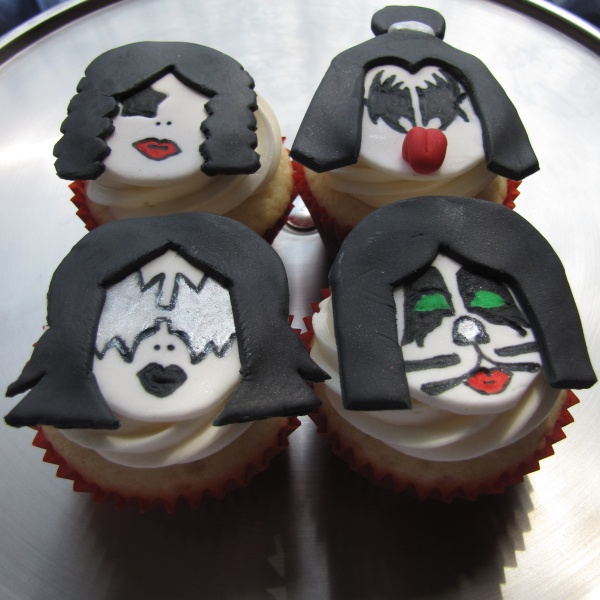 Vanilla cupcakes frosted with vanilla buttercream and topped with handcrafted fondant toppers to represent each of the four KISS band members. (Photo by Clever Cupcakes via Flickr/Creative Commons https://flic.kr/p/6Sc7Dx)