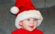 Baby boy smiles in his Santa hat
