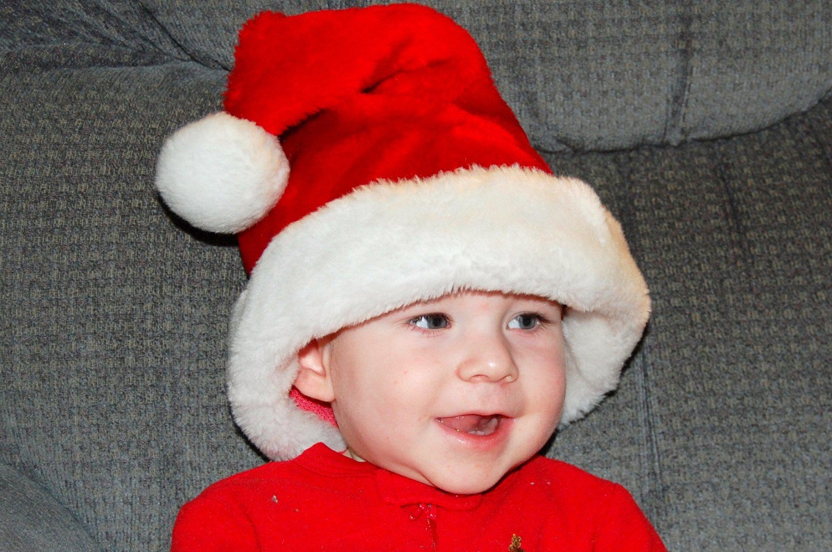 Baby boy smiles in his Santa hat