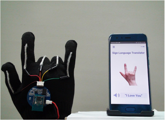 Smart glove makes sign for "I love you" and screen of smartphone shows the sign and the words "I love you" (photo Jun Chen Lab/UCLA)