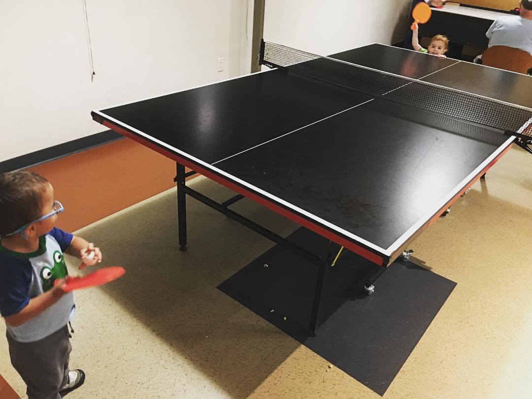 Two year old and one year old play table tennis