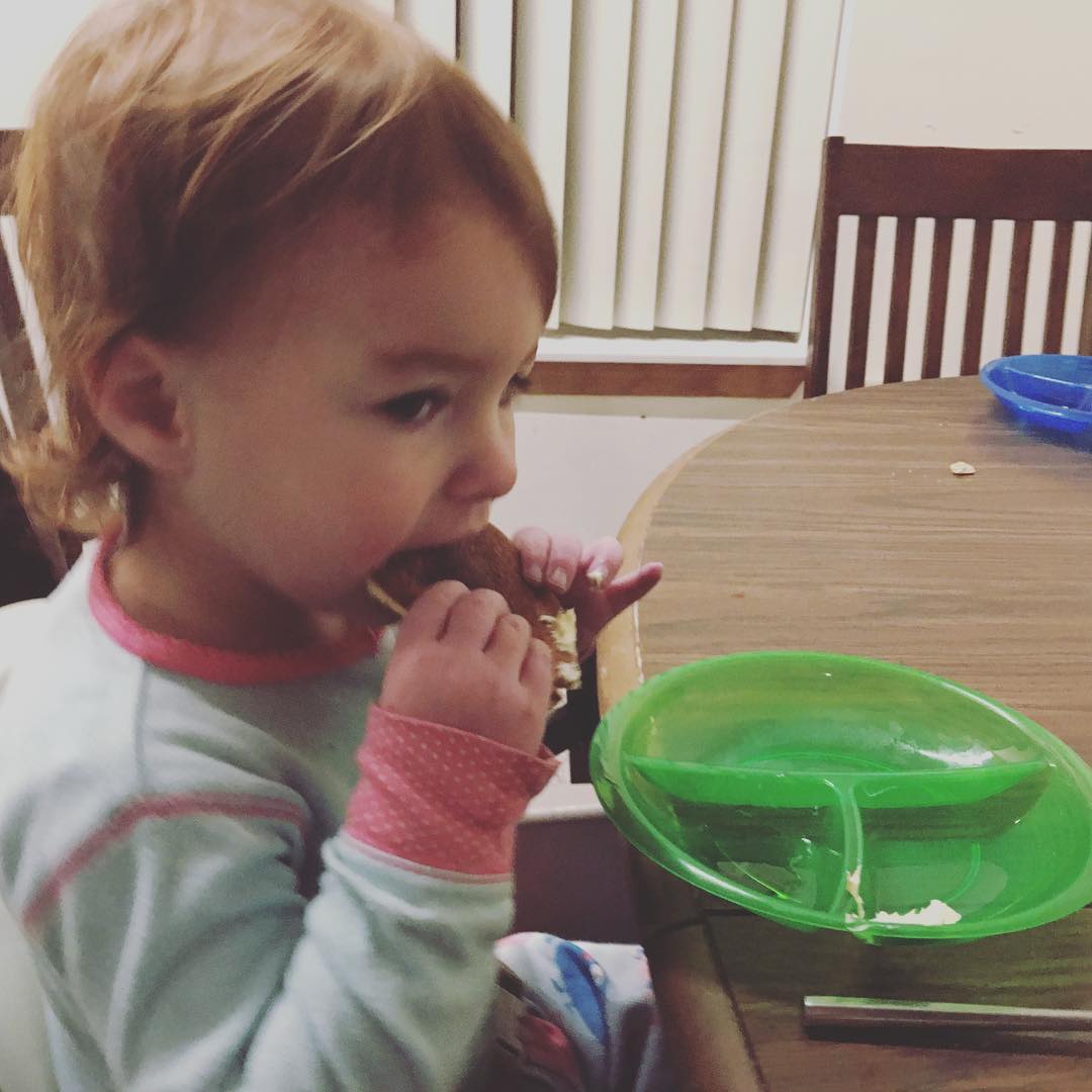 Two year old takes a bite of her pancake
