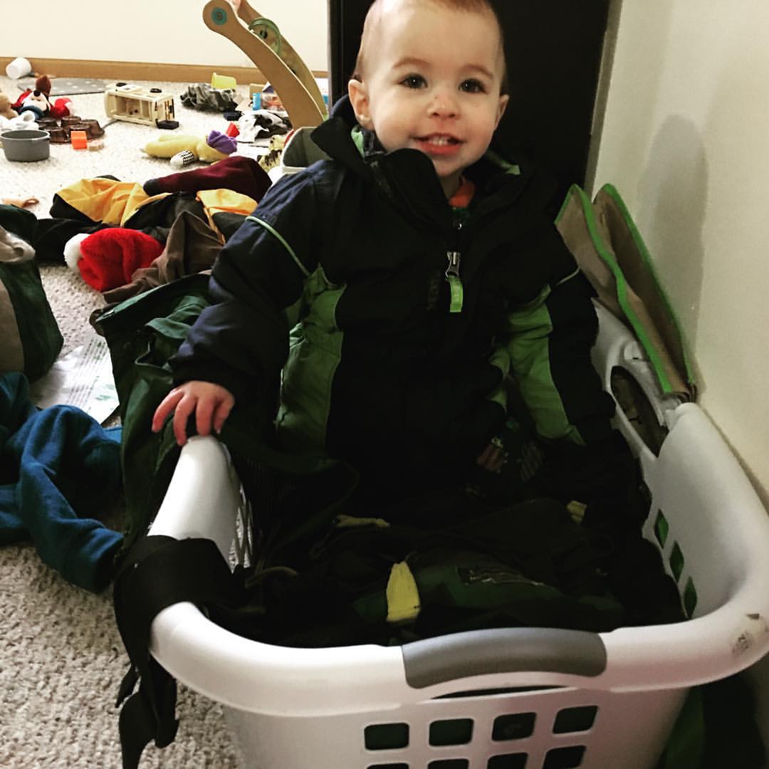 One year old sitting in a laundry basket