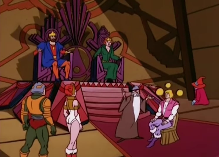 In Castle Greyskull's throne room, Zagraz the magician levitates three yellow balls over Prince Adam's head, while the other good guy characters watch