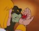 Prince Adam holds Cricket Orko in his right hand, while Cringer looks on
