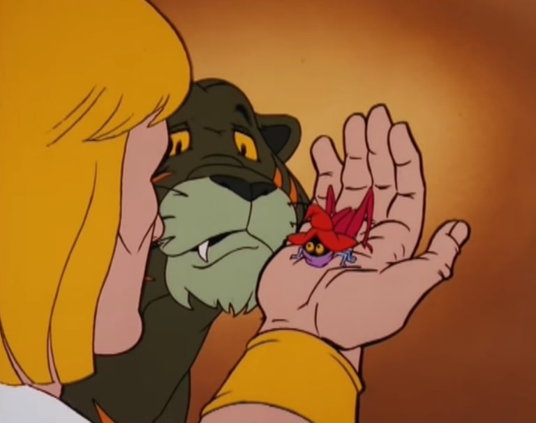 Prince Adam holds Cricket Orko in his right hand, while Cringer looks on