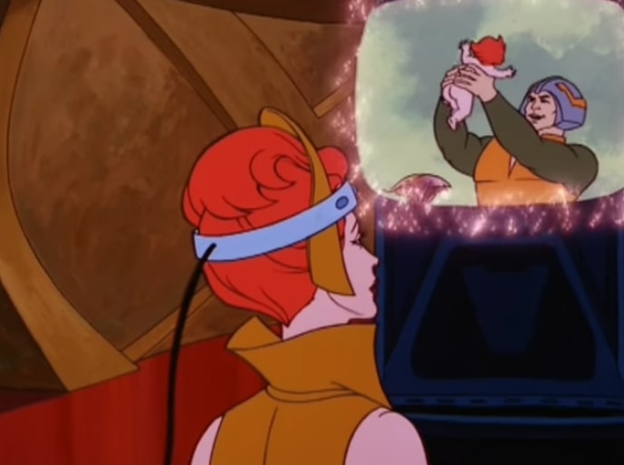 Teela wears a headband connected to the memory projector, and watches a memory of Man-at-Arms playing with her when she was a baby