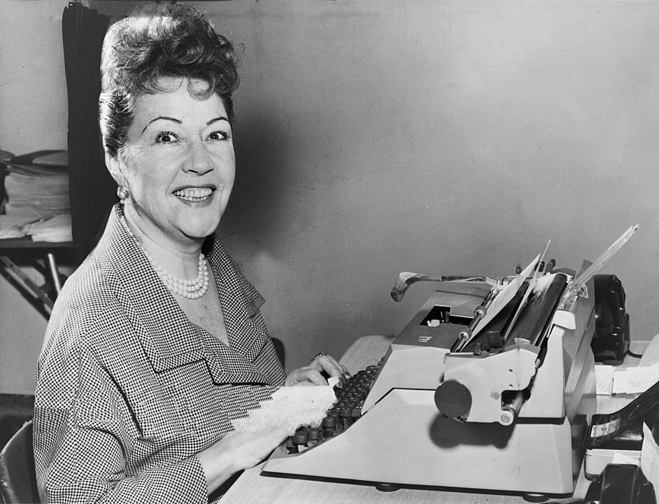 Ethel Merman seated at a typewriter. (Photo by Walter Albertin, derivative work: PawełMM via Wikicommons https://commons.wikimedia.org/w/index.php?curid=14387238)