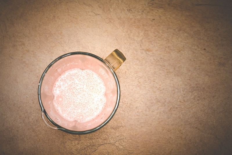 An overhead view of a glass pitcher holding a pink protein shake. (Photo by Kamil Kaczor via Flickr/Creative Commons https://flic.kr/p/V8ooYG)