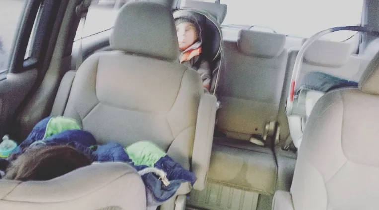 The kids are all in the back of the minivan for the first ride home as a family of five.