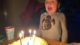 Six year old blows out the candles on his yellow lemon cake