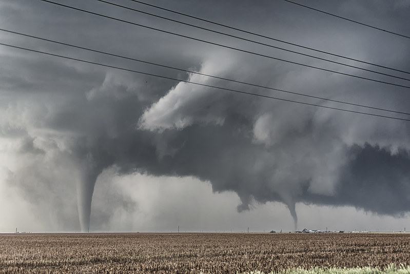 Two tornadoes touch down over a flat field. (Photo by Niccolò Ubalducci via Flickr/Creative Commons https://flic.kr/p/HZqP4q)
