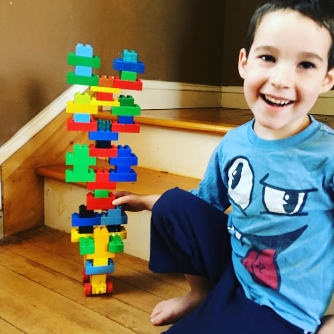 Five year old built a tall tower of Duplo figures - the robots - all standing on each other. He is very happy about this.