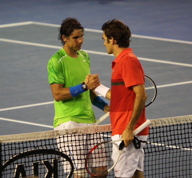 Rafael Nadal and Roger Federer shake hands after a match in 2012 (though not the match discussed in today's episode.) (Photo by brett marlow via Flickr/Creative Commons https://flic.kr/p/bjzrZK)