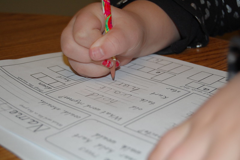 Closeup of a kid's hands as they do a worksheet. (Photo by Catherine via Flickr/Creative Commons https://flic.kr/p/5R39Qp)
