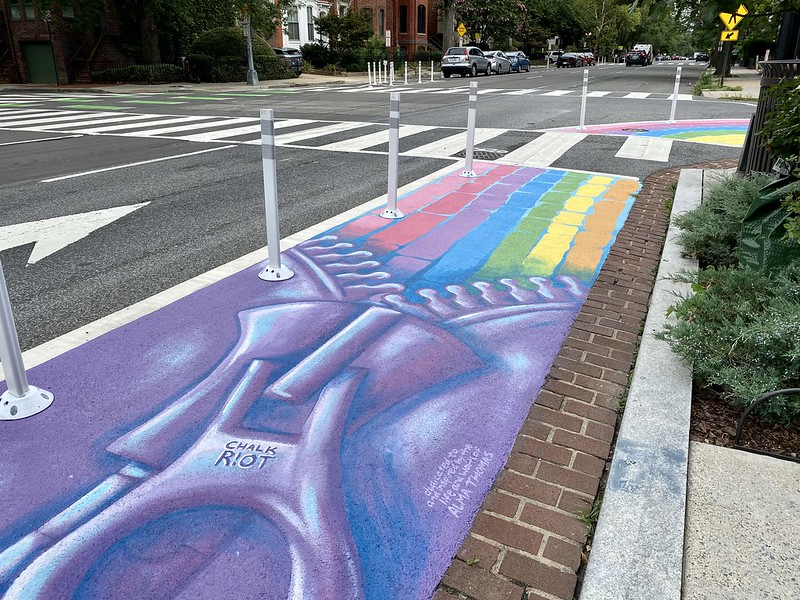 A street mural in Washington DC shows a zipper unzipping seven rows of rainbow-colored blocks, in tribute to the style of painter Alma Thomas. (Photo by Joe Flood via Flickr/Creative Commons https://flic.kr/p/2mfbp3F)