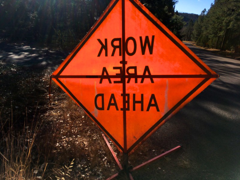 An orange "Work Area Ahead" road sign, shown from the reverse side. (Photo by Alan Levine via Flickr/Creative Commons https://flic.kr/p/21Ey6rE)