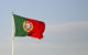 The national flag of Portugal: a bar of green on the left, red on the right, and the country's coat of arms near the center. (Photo by Ted van den Bergh via Flickr/Creative Commons https://flic.kr/p/ejbckk)