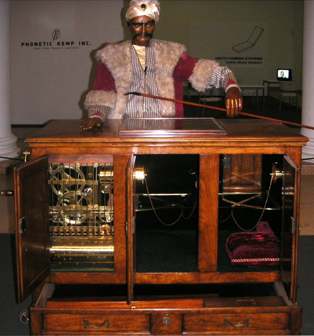 A reconstruction of the Turk, the chess-playing automaton designed by Kempelen. Photo by Carafe at English Wikipedia, CC BY-SA 3.0, https://commons.wikimedia.org/w/index.php?curid=7860391