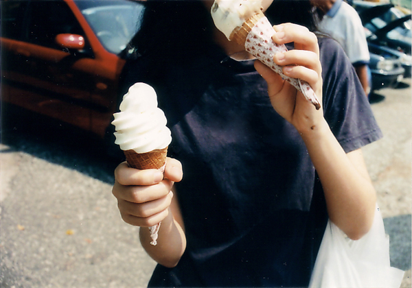 A person tasting an ice cream cone while holding a second cone. (Photo by r a c h e l via Flickr/Creative Commons https://flic.kr/p/kMp9U)