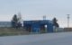 A blue, two lane car wash building with the word BAYWASH written in flashy, Baywatch-style lettering.