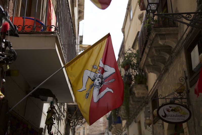 The flag of Sicily hangs on a street. (Photo by Nuno Cardoso via Flickr/Creative Commons https://flic.kr/p/vJaJbS)