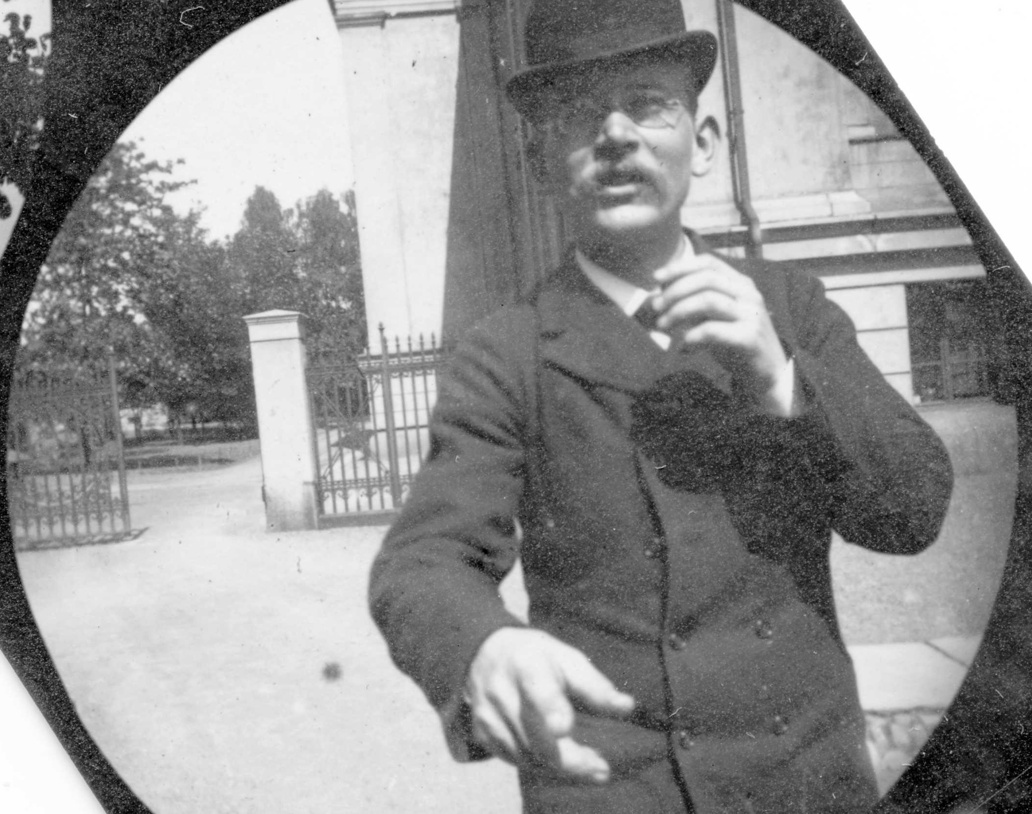 A round camera image shows a man in a top hat and a suit out for a walk.