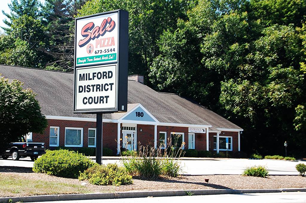 A sign says "Sal's Pizza" - underneath it the sign reads "Milford District Court"