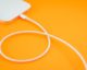 A white charging cable connects to a white smartphone, with a bright orange background. (Photo by Holger Prothmann via Flickr/Creative Commons https://flic.kr/p/2ngSZfA)