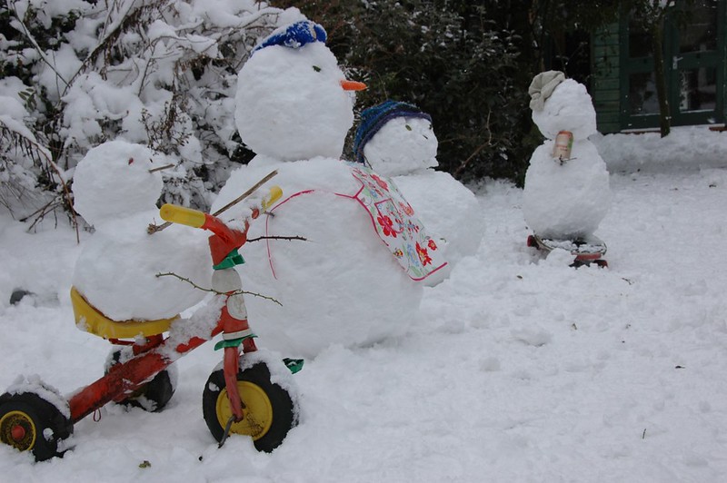 A group of snow people out in the winter. One is even riding a tricycle. (Photo by henry... via Flickr/Creative Commons https://flic.kr/p/5WYuE1)