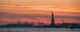 The Statue of Liberty at sunset, with a bright orange sky in the background. (Photo by ChrisGoldNY via Flickr/Creative Commons https://flic.kr/p/RHquTU)