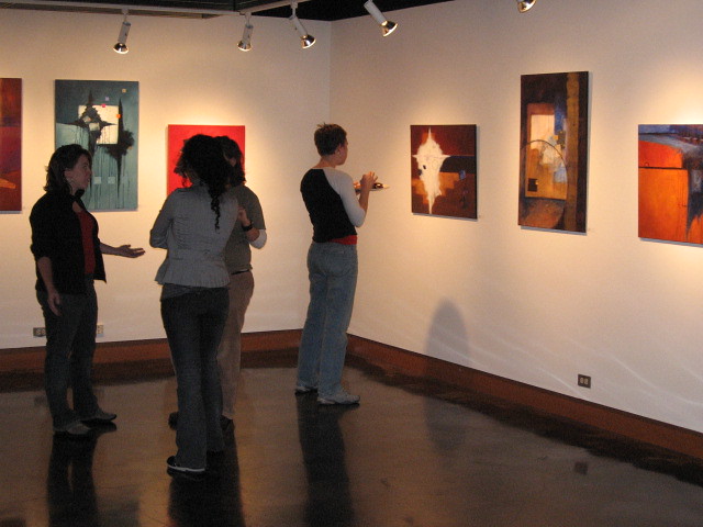 People look at paintings at an art gallery. (Photo by Wade Rockett via Flickr/Creative Commons https://flic.kr/p/rzTs8)