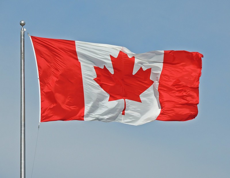A Canadian flag flying on a pole. (Photo by Robert Pruner via Flickr/Creative Commons https://flic.kr/p/gbXyxk)