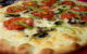 A close-up of a pizza with cheese, tomato slices, mushrooms and green peppers as toppings. Photo by Robert via Flickr/Creative Commons https://flic.kr/p/6jVfLJ