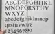 The alphabet, in upper and lower case text, plus the ten digits, all printed in Times New Roman font on two pages of a book. A hand is holding the bottom left side of the left page. Photo by Nick Sherman via Flickr/Creative Commons https://flic.kr/p/2o3krr6